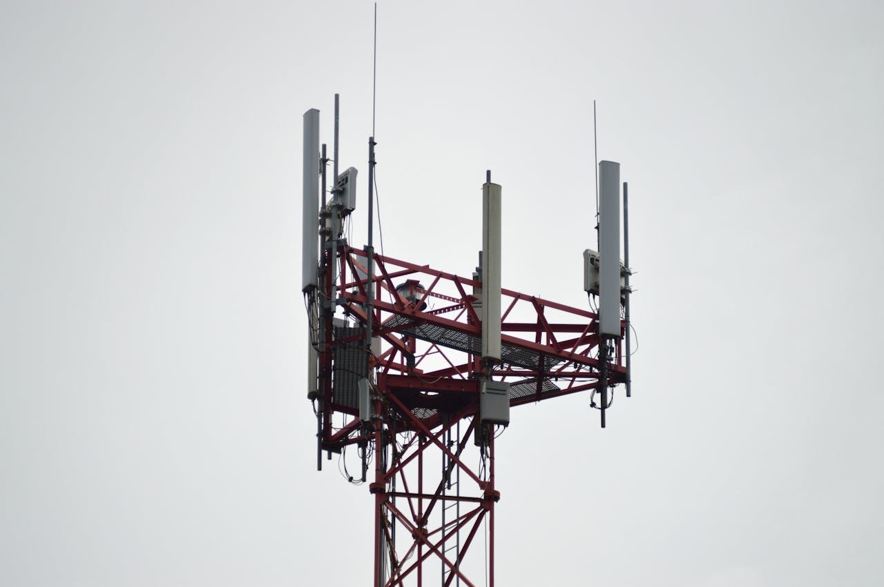 hero-homepage A red communication tower with antennas stands tall against a gray sky.